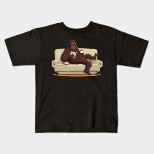 Bigfoot sit on sofa, read a book and drink coffee Kids T-Shirt